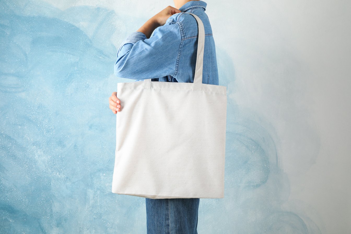 Young Woman Holding Tote Bag against Blue Background, Empty Spac